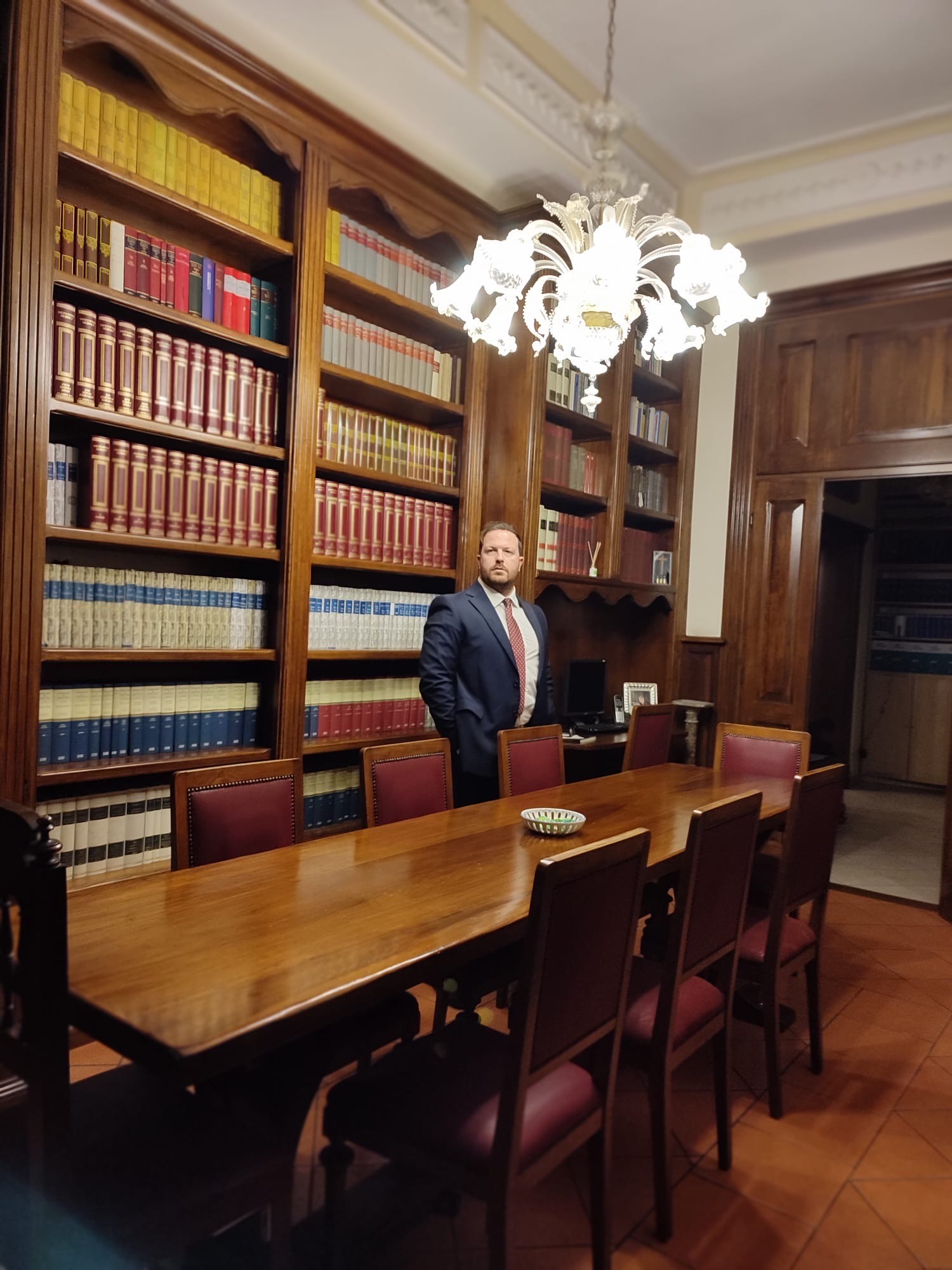 avv Angeletti in piedi davanti a libreria